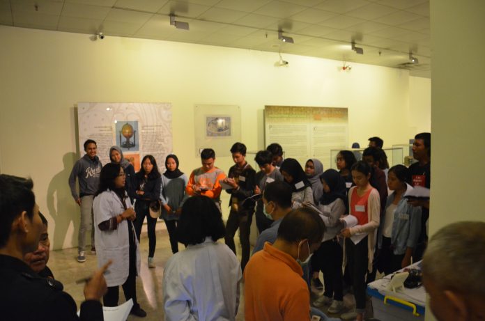 Mahasiswa Jurusan Arkeologi UI Mendengarkan penjelasan